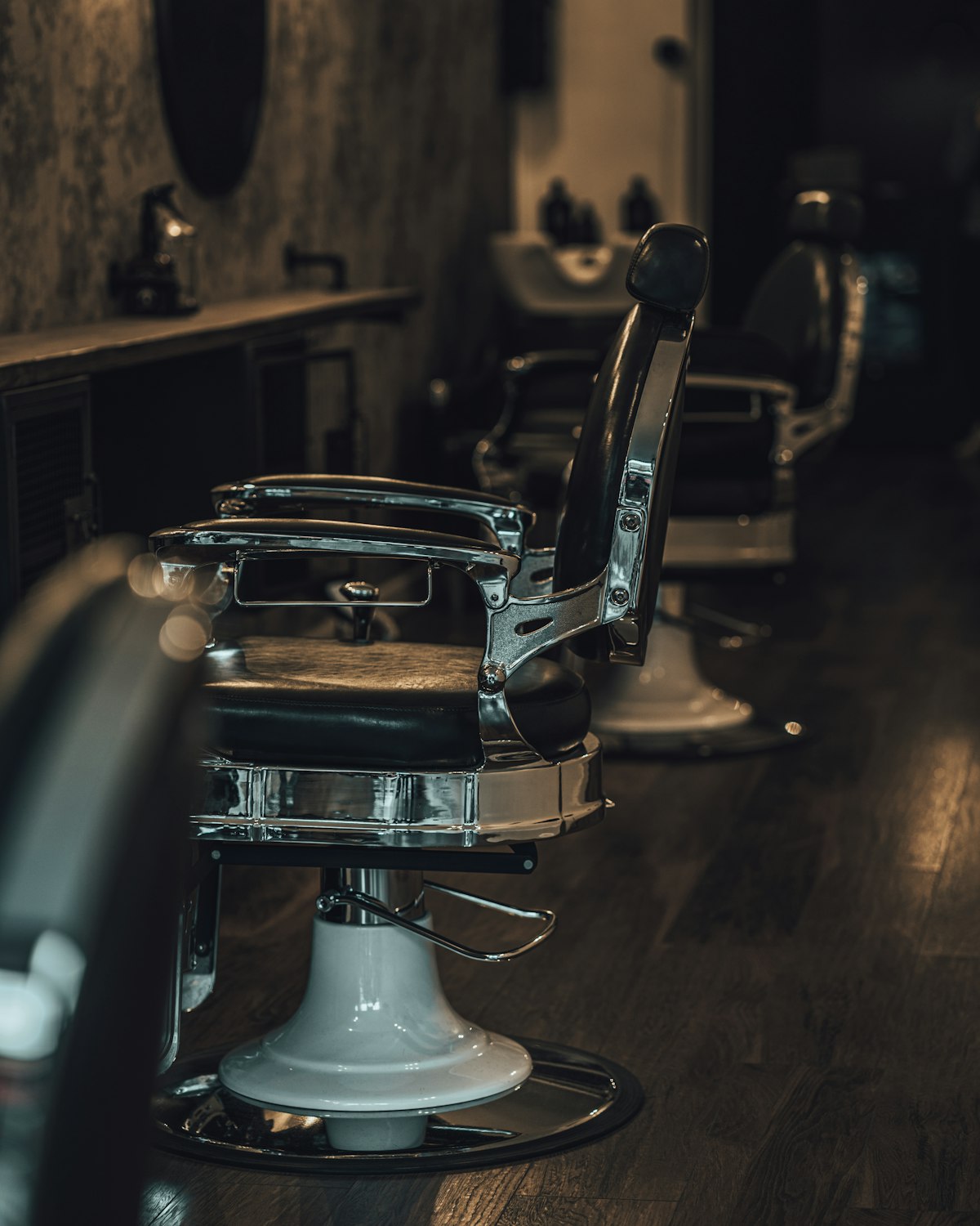 Vintage barber chair with chrome base in a dark room