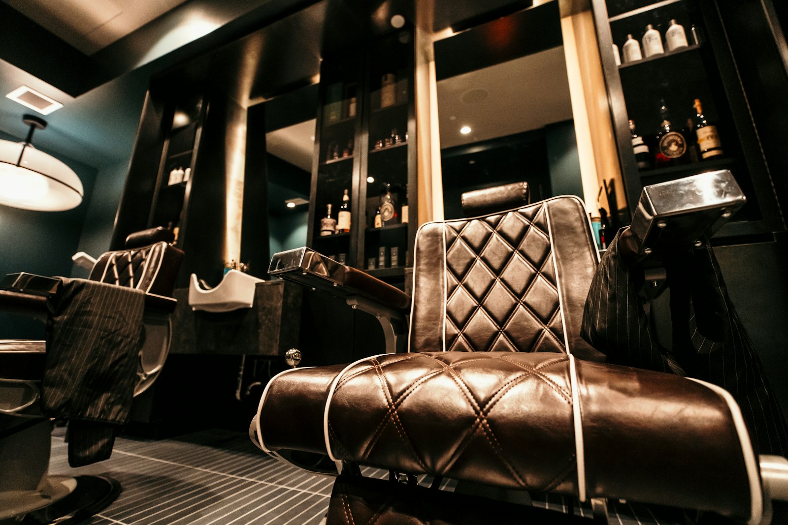 Black leather barber chair against a brick wall