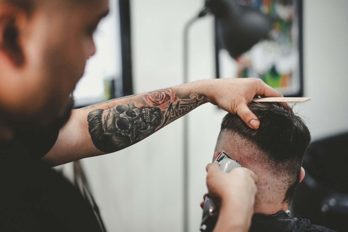 Barber blending a skin fade with clippers